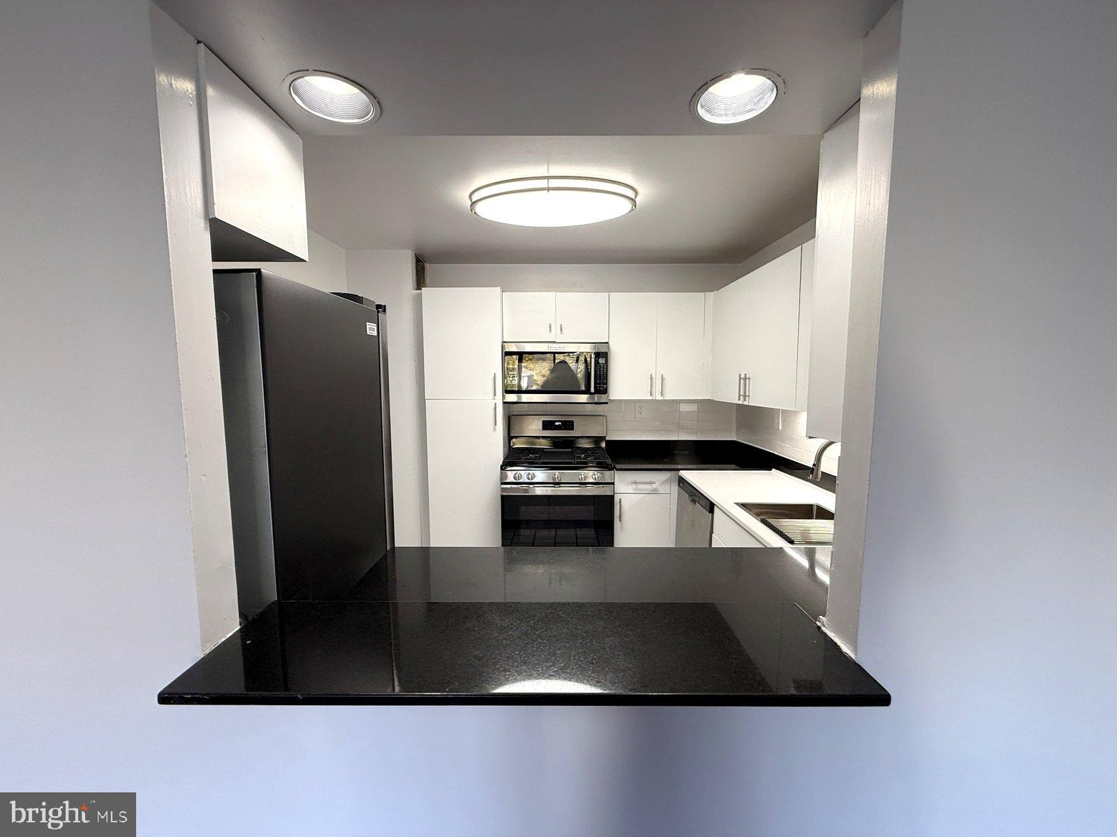 606 Cooper Landing Road, Unit A3E Cherry Hill, NJ 08002 - Photo 6 of 17 a kitchen with granite countertop a refrigerator and a stove