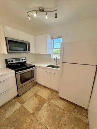 a kitchen with stainless steel appliances a refrigerator sink and microwave