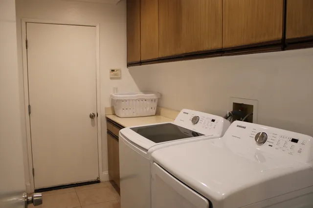 a close up of a utility room with dryer and washer