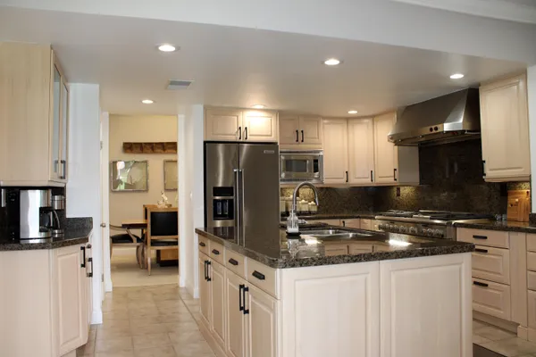 a kitchen with stainless steel appliances granite countertop a refrigerator stove microwave and sink