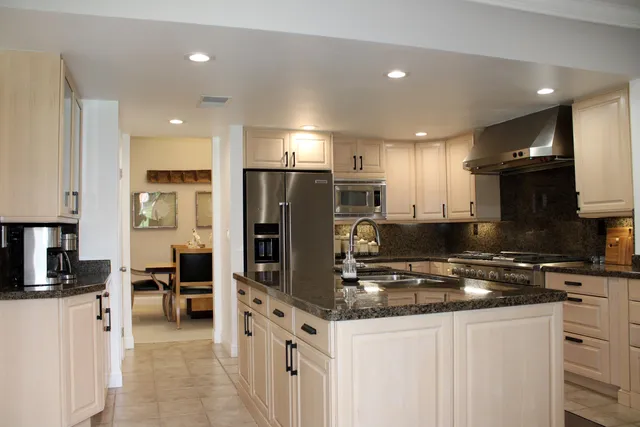 a kitchen with stainless steel appliances granite countertop a refrigerator stove microwave and sink