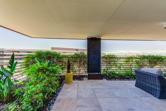 a view of a patio with couches chairs potted plants and ocean view