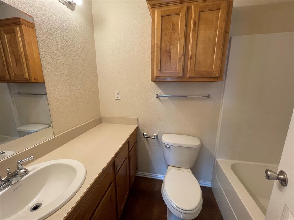 100 Crossbow Court, Unit 102 Weatherford, TX 76088 - Photo 17 of 21 a bathroom with a sink a toilet and a mirror