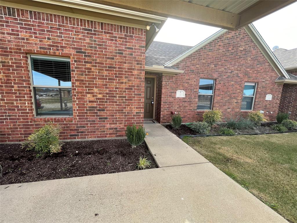 100 Crossbow Court, Unit 102 Weatherford, TX 76088 - Photo 19 of 21 a view of a brick house with yard