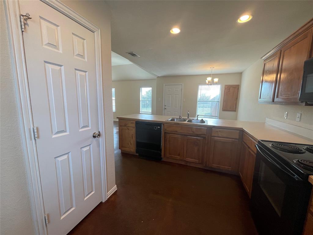 100 Crossbow Court, Unit 102 Weatherford, TX 76088 - Photo 6 of 21 a kitchen with a sink and a stove top oven