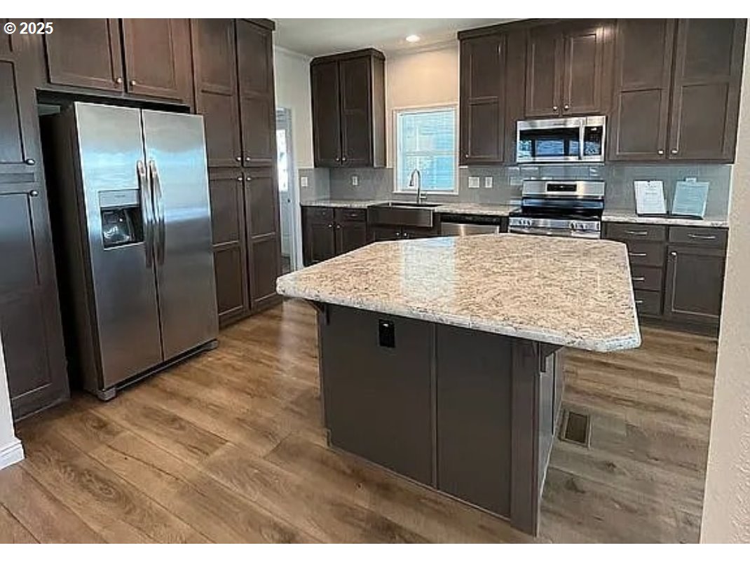 15889 Sunset Strip, Unit 7 Brookings, OR 97415 - Photo 5 of 10 a kitchen with kitchen island a counter top space a sink and stainless steel appliances