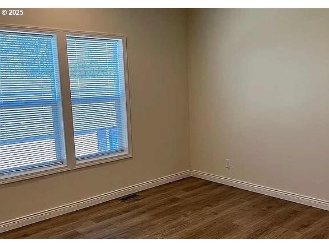 15889 Sunset Strip, Unit 7 Brookings, OR 97415 - Photo 7 of 10 a view of an empty room with wooden floor and a window