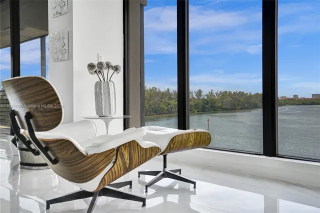a living room with stainless steel appliances furniture a refrigerator and kitchen view
