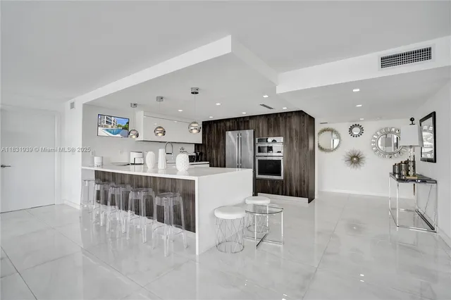 a large kitchen with a large counter top stainless steel appliances and cabinets
