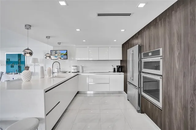 a kitchen with kitchen island granite countertop a sink cabinets and stainless steel appliances