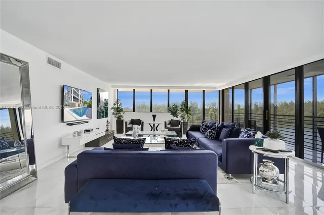 a living room with furniture large window and a table