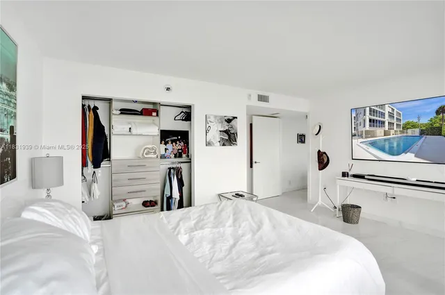 a bedroom with furniture and a large window