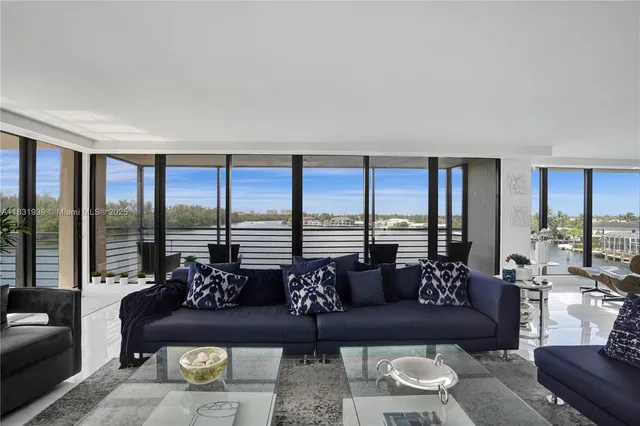 a living room with furniture large windows and a view of lake