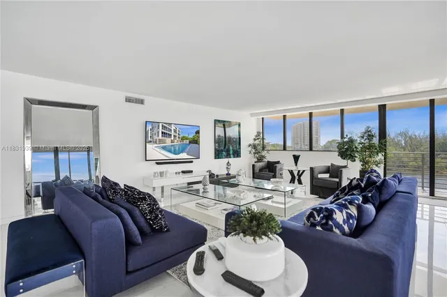 a living room with furniture and large windows