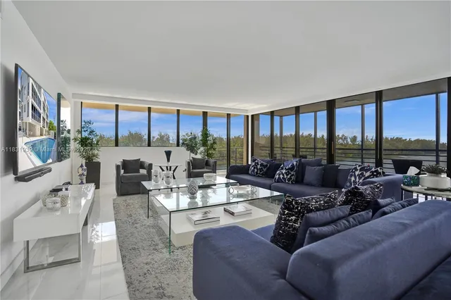 a living room with furniture and floor to ceiling windows