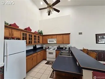 a kitchen with stainless steel appliances a refrigerator a sink a stove and white cabinets