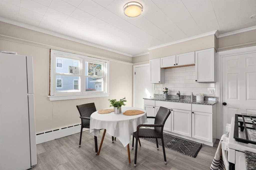 27 Dresser Street Webster, MA 01570 - Photo 13 of 33 a kitchen with granite countertop a dining table chairs and white cabinets