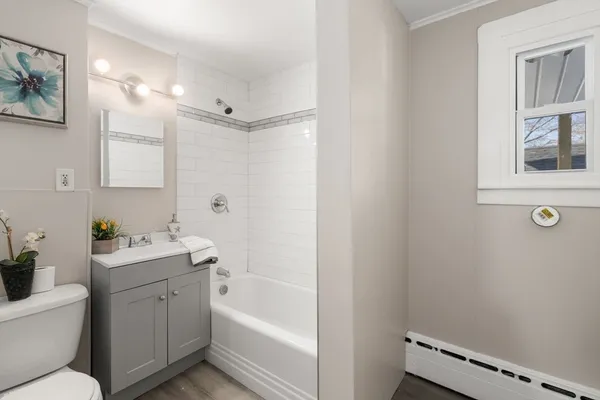a bathroom with a tub sink toilet and a mirror