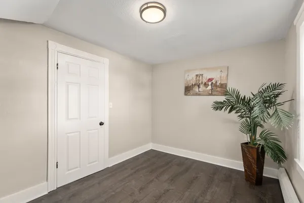 an empty room with a potted plant and wooden floor
