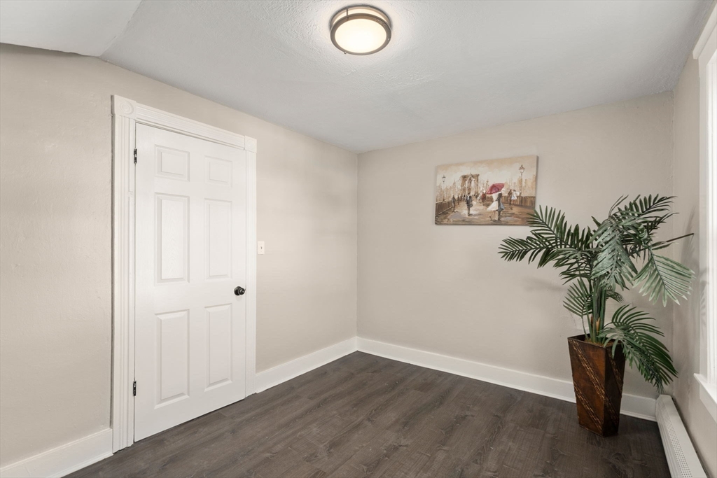 27 Dresser Street Webster, MA 01570 - Photo 20 of 33 an empty room with a potted plant and wooden floor