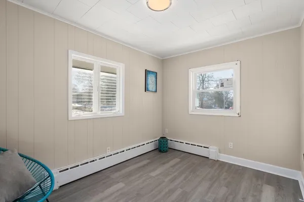 a view of an empty room with a window and wooden floor