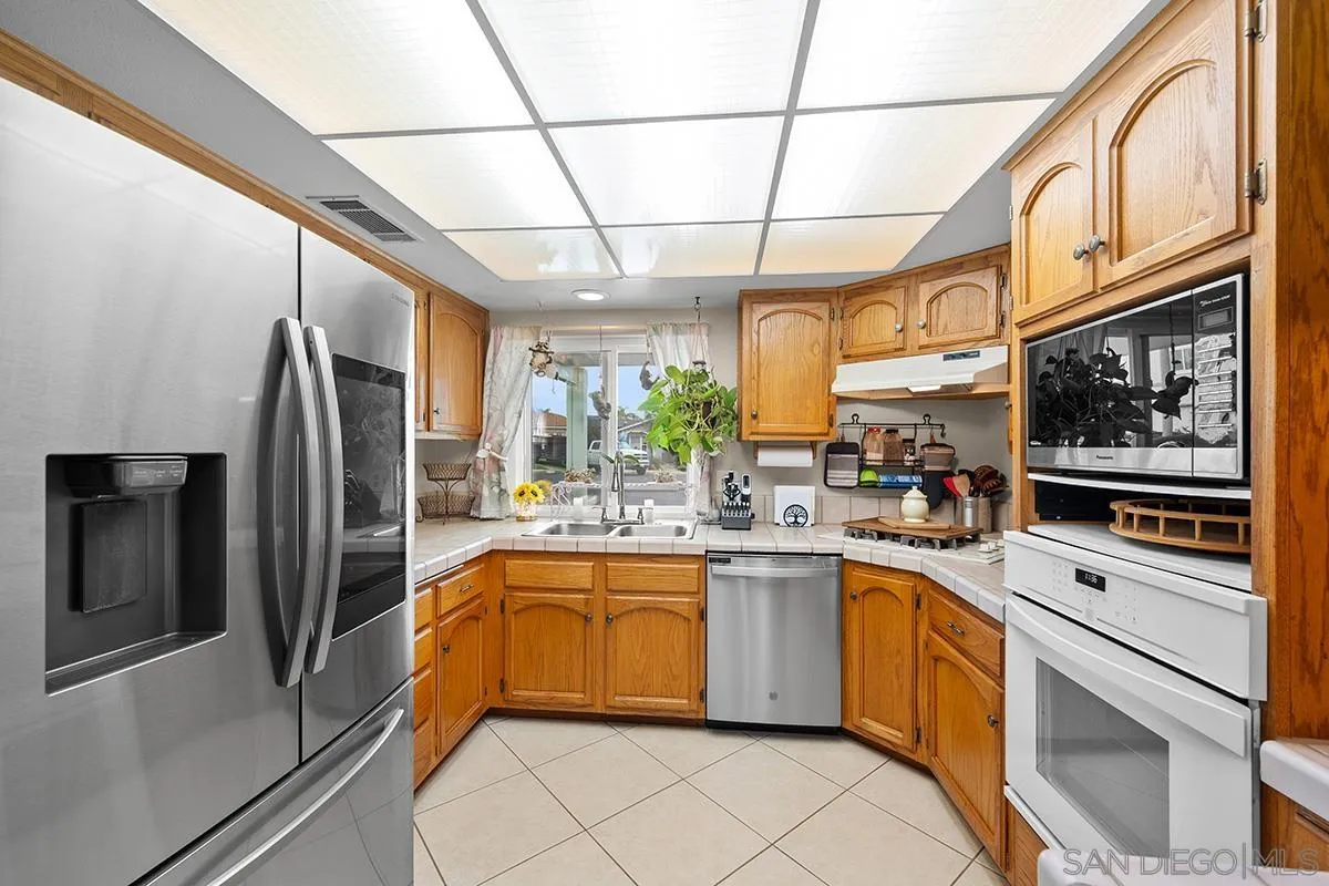 9948 Kincaid Street Santee, CA 92071 - Photo 11 of 53 a kitchen with a sink stainless steel appliances and cabinets