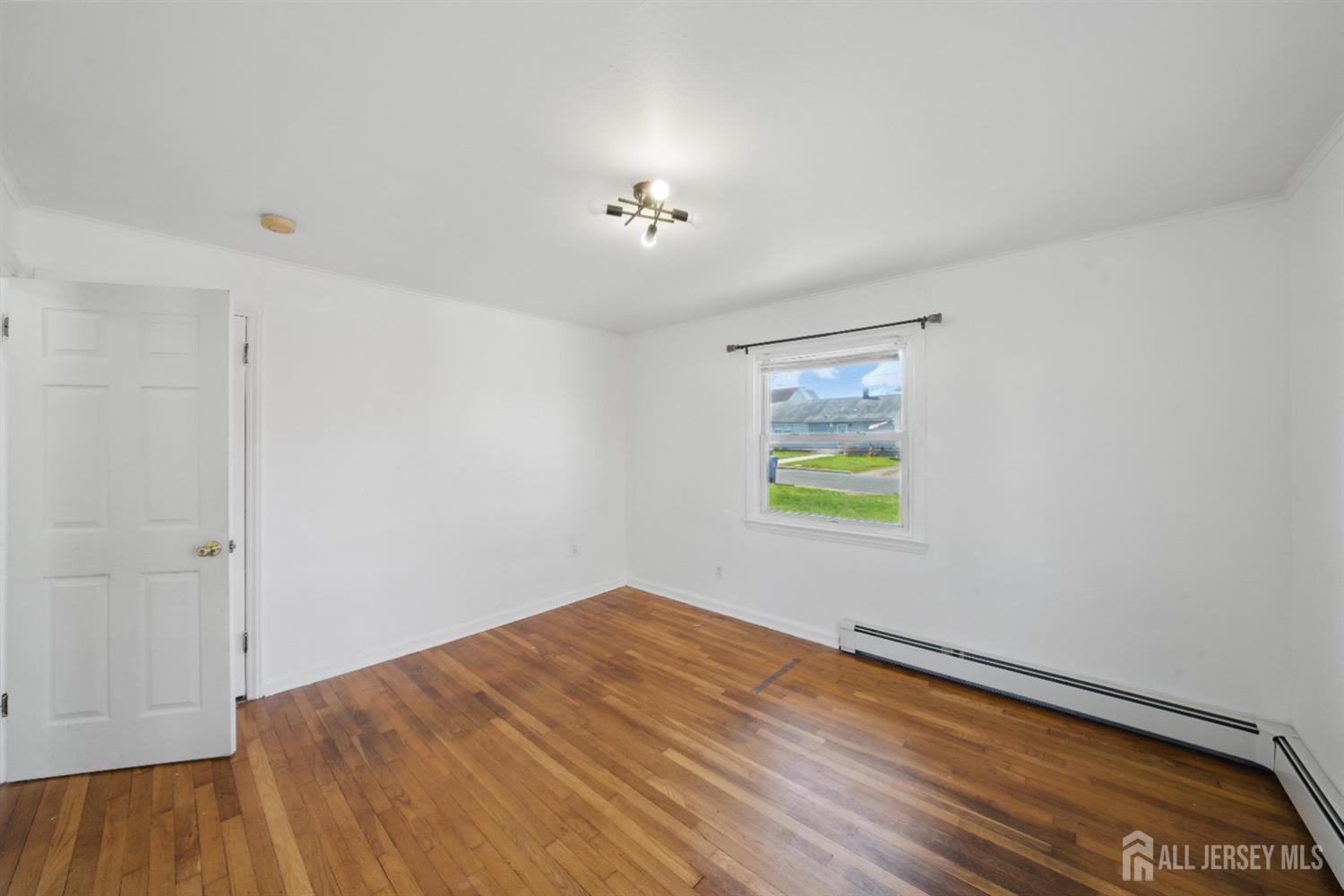 94 South Hill Road Colonia, NJ 07067 - Photo 14 of 31 wooden floor in an empty room with a window