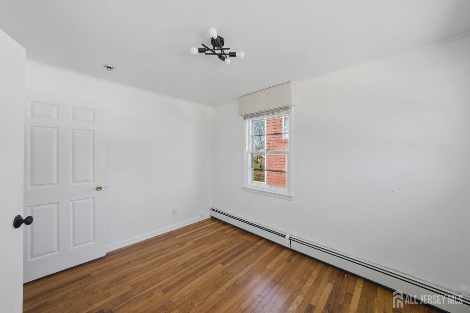 94 South Hill Road Colonia, NJ 07067 - Photo 18 of 31 a view of an empty room with wooden floor and a window