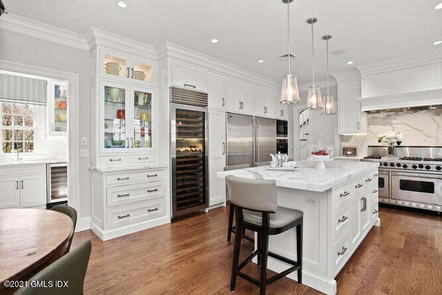 a dining room with furniture a rug a potted plant and a chandelier