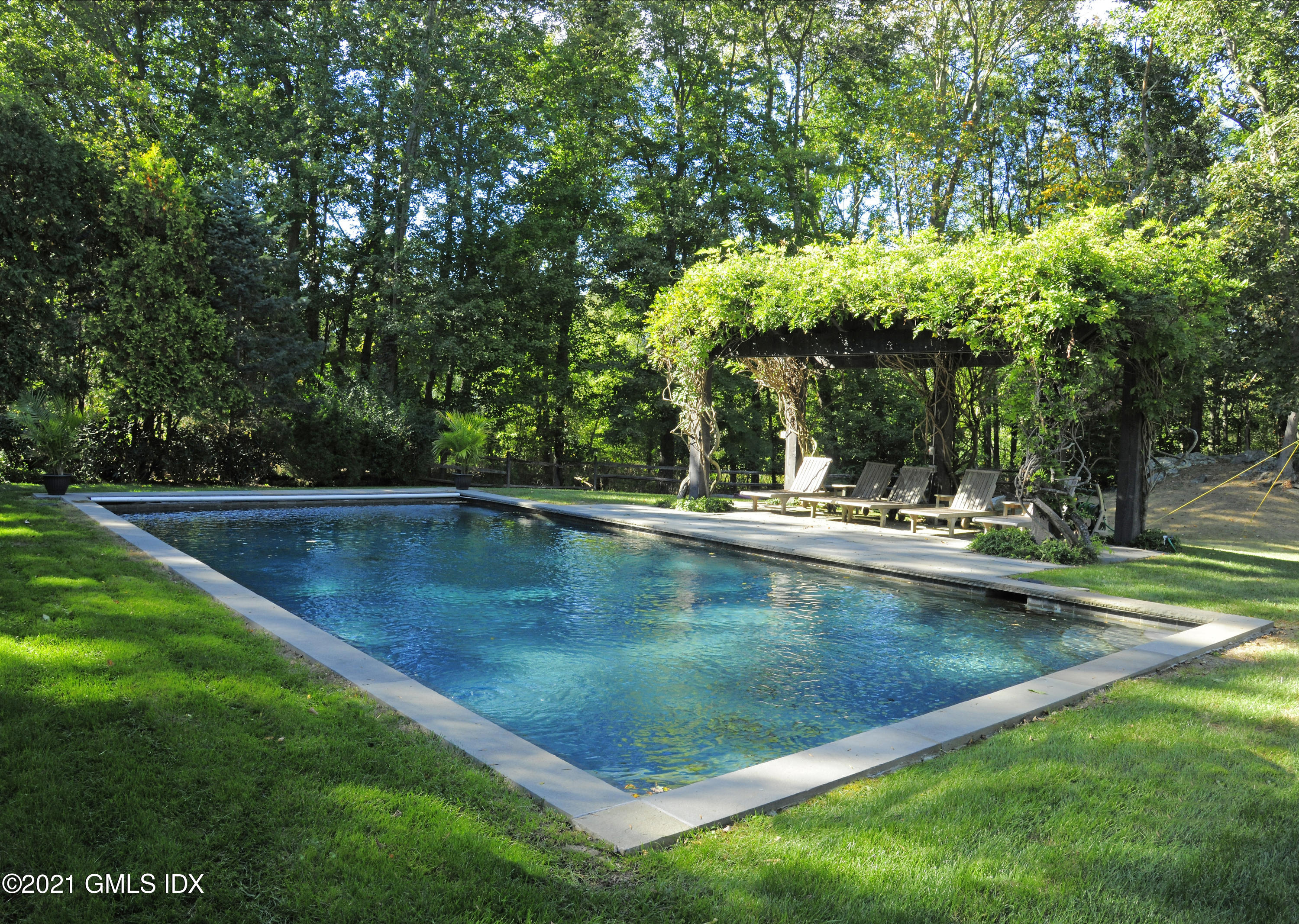 7 Desiree Drive Greenwich, CT 06830 - Photo 2 of 39 a view of a swimming pool and trees in the background