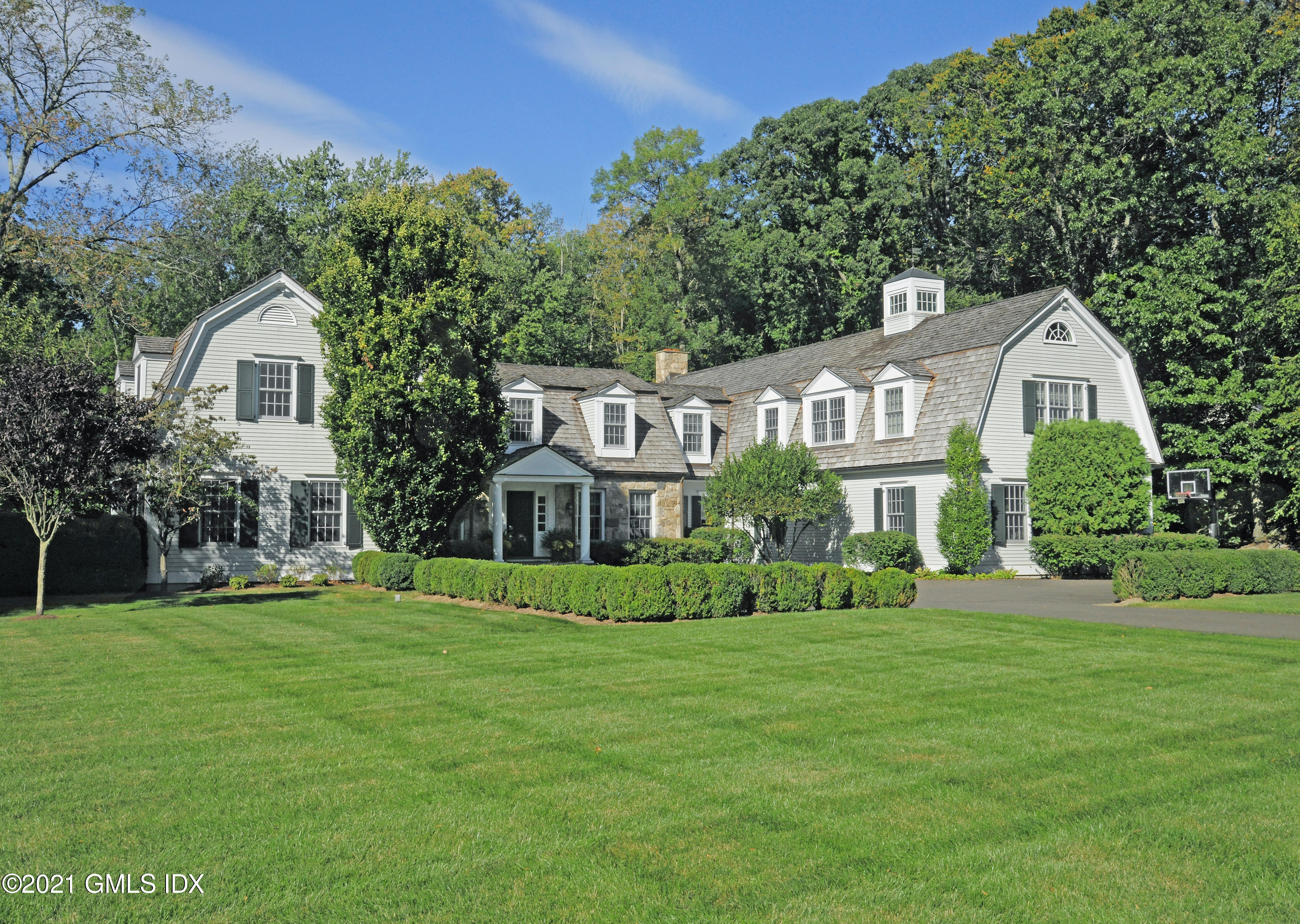 7 Desiree Drive Greenwich, CT 06830 - Photo 3 of 39 a view of a house next to a big yard and large trees