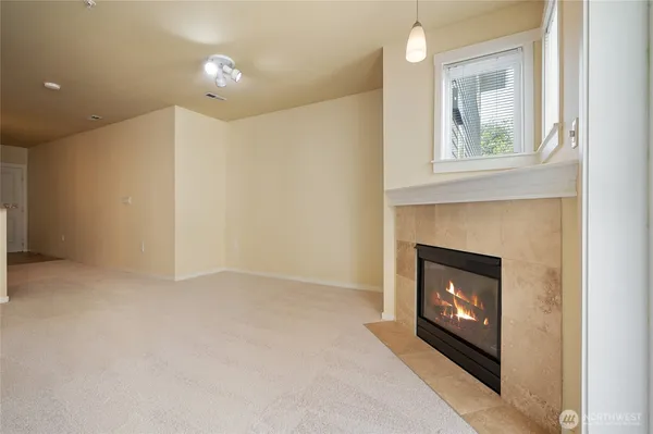 a view of an empty room with a fireplace and a window