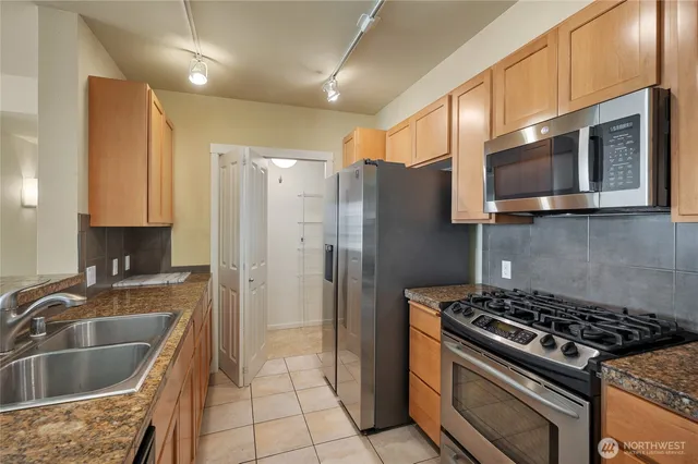 a kitchen with stainless steel appliances granite countertop a sink stove and refrigerator
