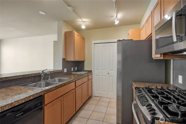 a kitchen with granite countertop a sink stove and cabinets