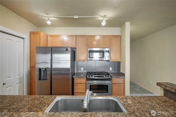 a kitchen with a refrigerator and a stove top oven