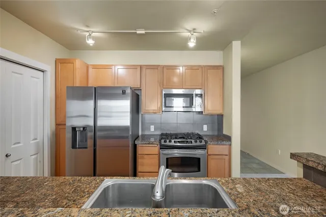 a kitchen with a refrigerator and a stove top oven