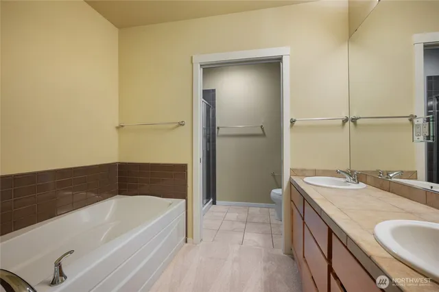 a bathroom with a granite countertop sink and a bathtub