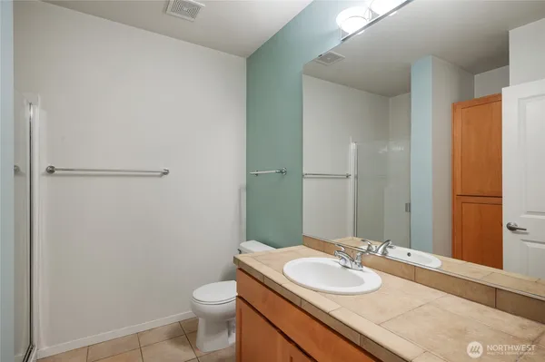 a bathroom with a granite countertop sink toilet and a mirror