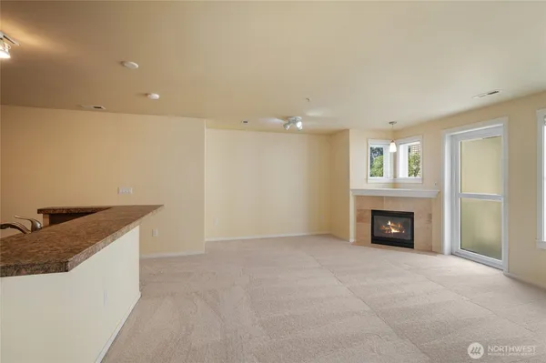 a view of an empty room with a fireplace and a window