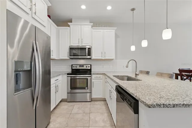 a kitchen with a sink counter top space appliances and cabinets