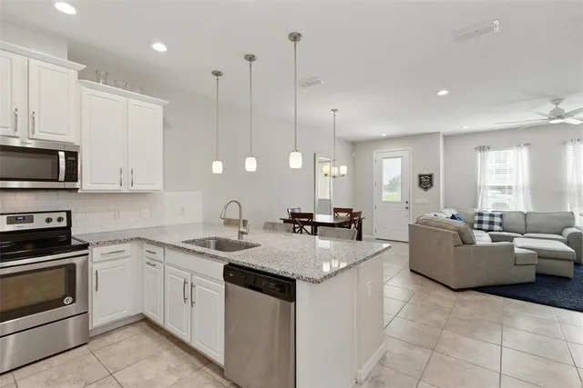 a kitchen with granite countertop a sink a counter top space and cabinets