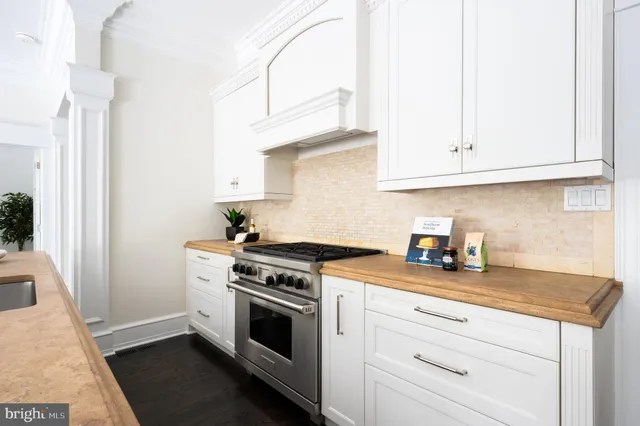 a kitchen with granite countertop white cabinets and white appliances