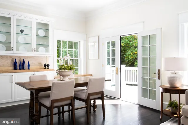 a dining room with wooden floor a glass table and chairs