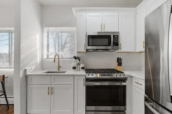 a kitchen with cabinets stainless steel appliances a sink and a stove