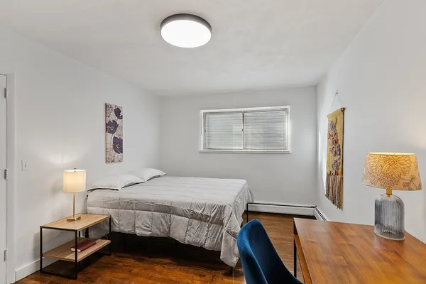 a bedroom with a bed and wooden floor