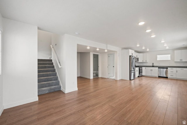 70 East Weekes Way Clearfield, UT 84015 - Photo 6 of 25 Unfurnished living room with stairway, light wood finished floors, and recessed lighting