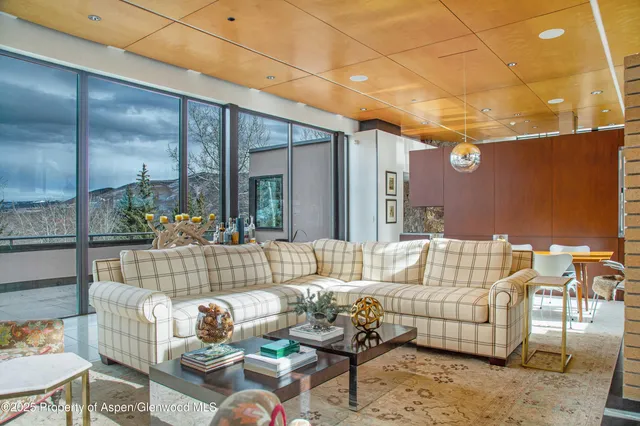 a living room with furniture and a floor to ceiling window