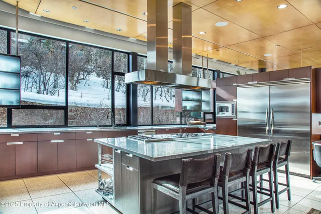 a utility room with stainless steel appliances a stove and a refrigerator
