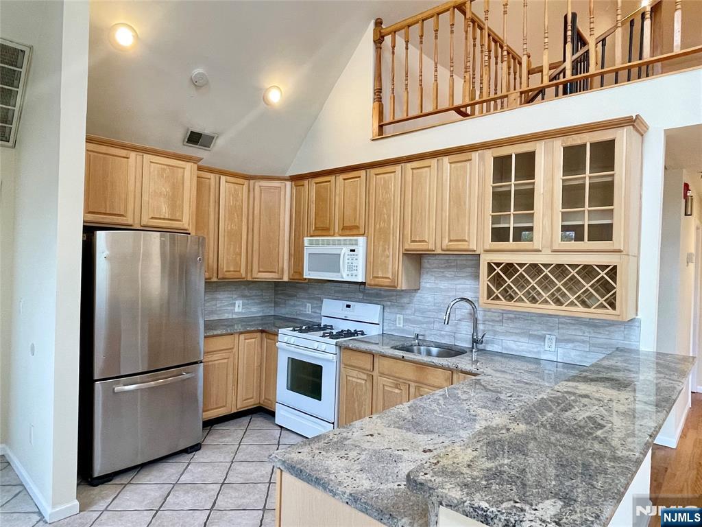 662 Undercliff Avenue, Unit 2 Edgewater, NJ 07020 - Photo 2 of 17 a kitchen with stainless steel appliances granite countertop a refrigerator sink and cabinets