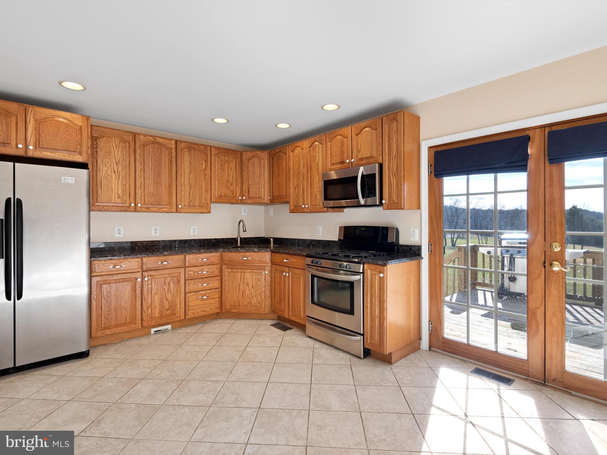 176 Old Mill Road Conowingo, MD 21918 - Photo 11 of 20 a kitchen with granite countertop a stove a sink and a refrigerator